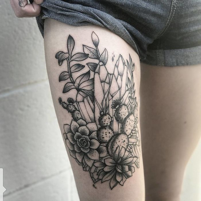 Thigh tattoo featuring detailed succulent design with various plants and crystals.