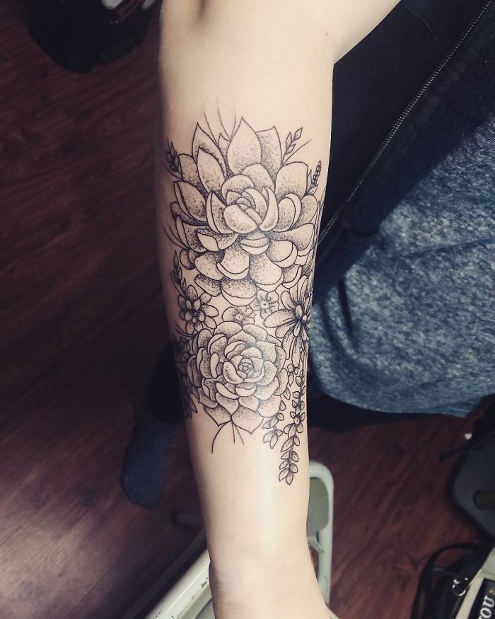 Succulent tattoo design on forearm with intricate floral details.