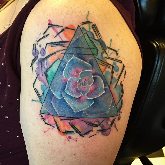 Colorful succulent tattoo with geometric shapes on an arm, showcasing unique succulent design ideas.