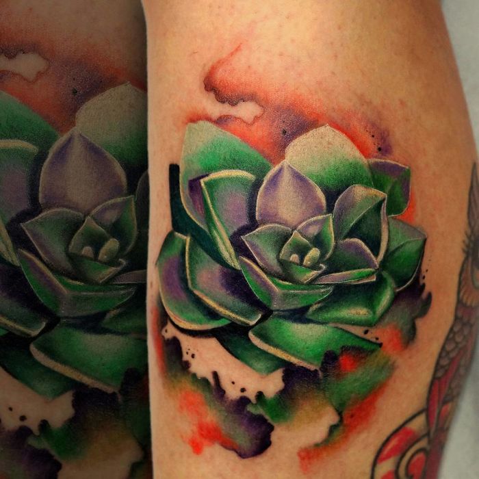 Colorful succulent tattoo on arm with green and purple hues, featuring vibrant artistic shading.