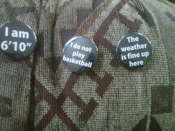 Pins on fabric humorously highlighting tall people struggles, including height and common misconceptions about basketball and weather.