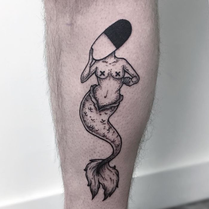 Tattoo of a headless mermaid on a person's leg, showcasing unique body art.