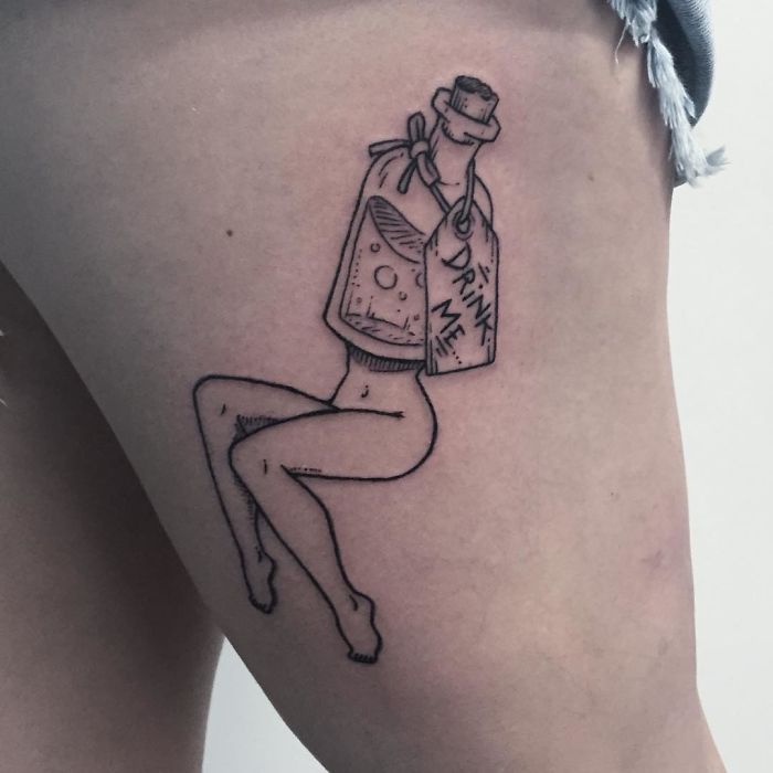 Tattoos of a headless girl with a bottle reading "Drink Me" on the thigh, by Molly Jean.