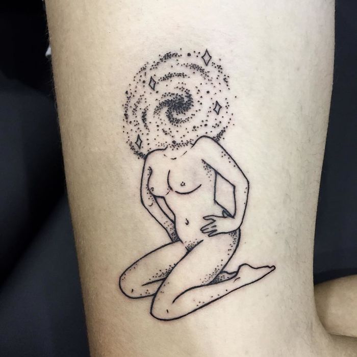 Tattoo of a headless girl with a galaxy swirl, designed by Molly Jean, on a person's arm.