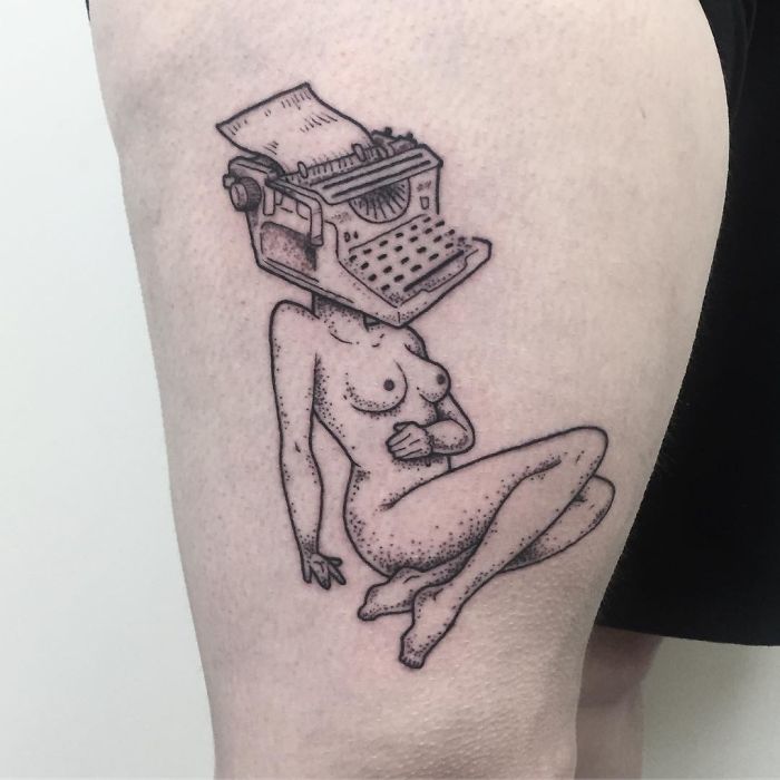 Tattoo of a headless girl with a typewriter for a head, crafted by Molly Jean.