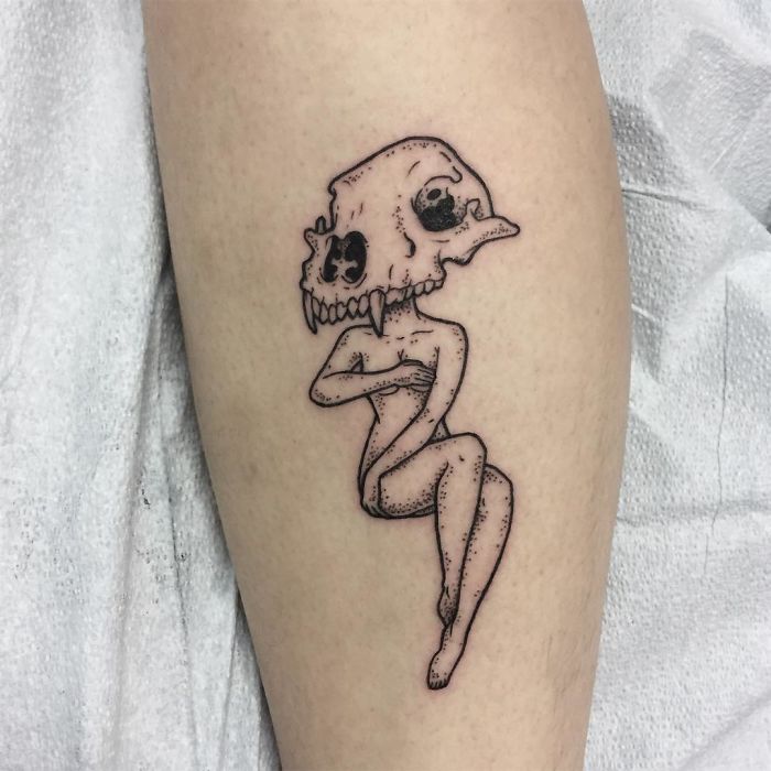 Tattoo of a headless girl with an animal skull, designed by Molly Jean, on a person's leg.