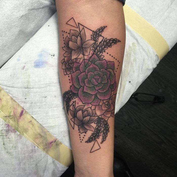 Tattoo featuring colorful succulent design with geometric elements on forearm.