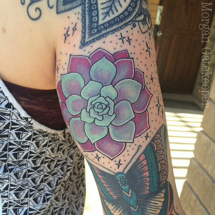 Colorful succulent tattoo design on arm, featuring purple and green hues, ideal for succulent enthusiasts.