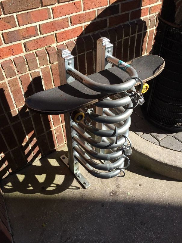 Innovative school idea: a skateboard lock rack attached to a brick wall outside, designed for student convenience.