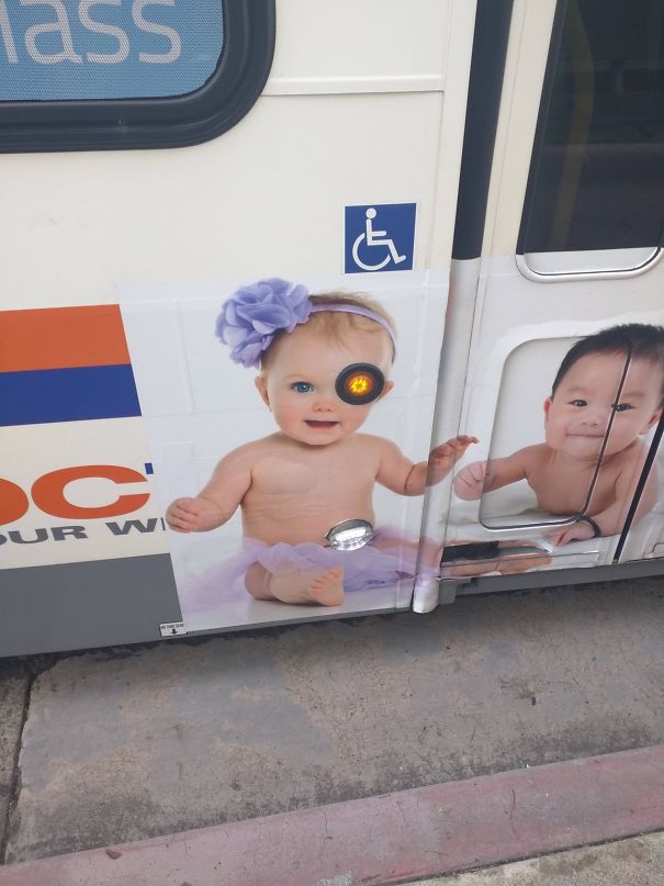 Baby design fail on bus ad alignment; traffic light covers one eye, creating accidental pirate look.