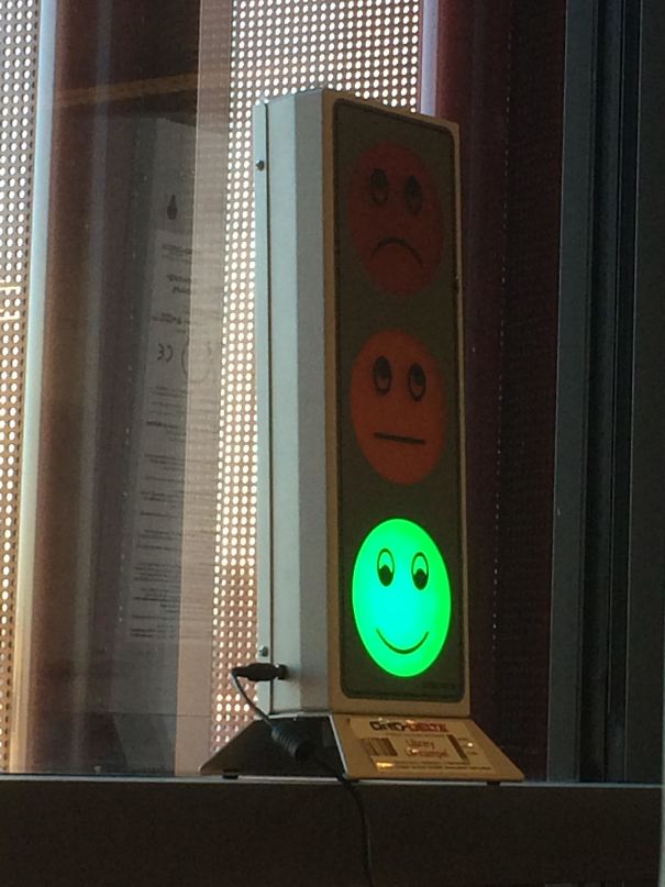 Traffic light feedback system in a classroom showing a green happy face.