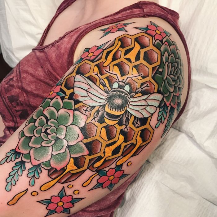 Colorful succulent tattoo with bees and honeycomb on arm.