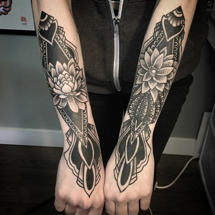 Succulent tattoos with intricate designs on both forearms, featuring floral and geometric elements.