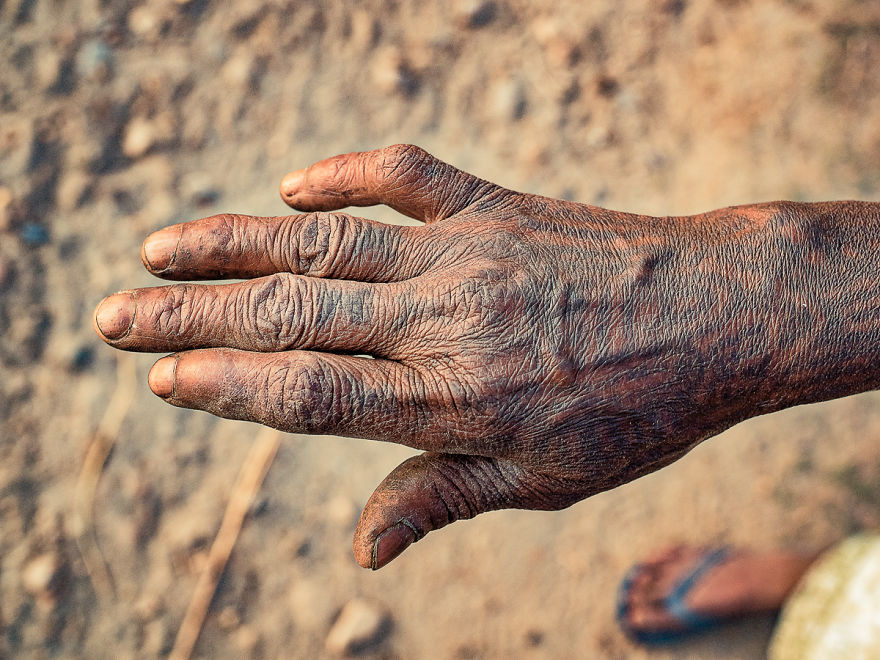 Tattooed hand of an elderly Tharu woman, showcasing traditional designs and cultural heritage.