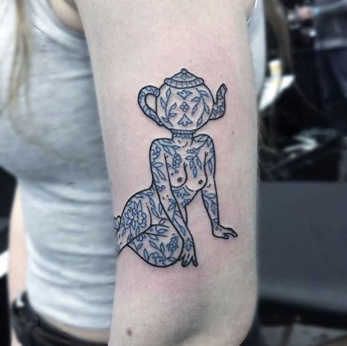 Tattoo of a headless girl with a teapot as a head on an arm, featuring floral patterns by Molly Jean.