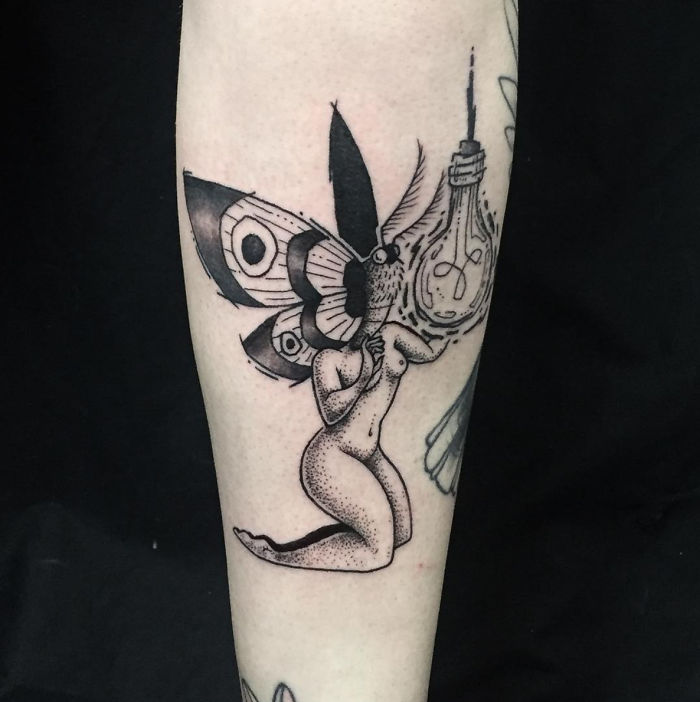 Tattoo of headless girl with butterfly wings and lightbulb by Molly Jean on forearm.