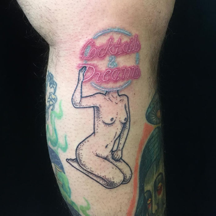 Headless girl tattoo with "Cocktails & Dreams" text on upper arm, designed by Molly Jean.