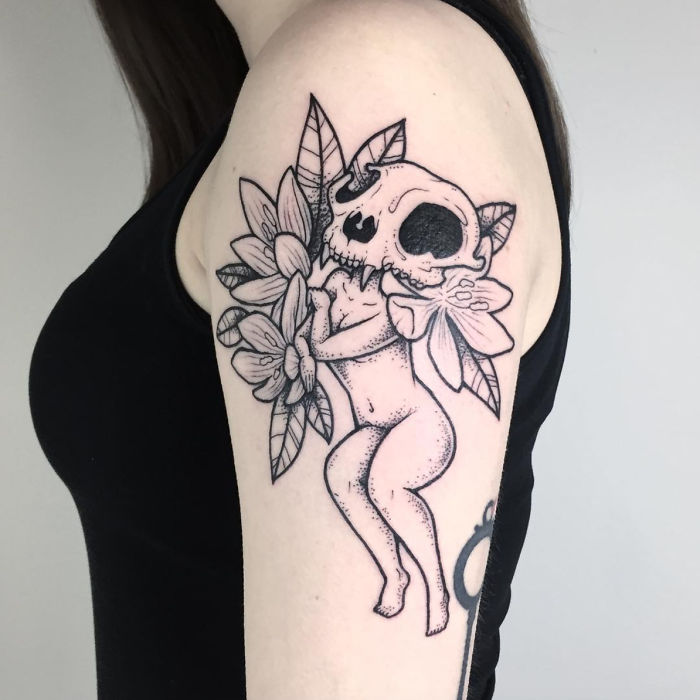 Tattoo of a headless girl with a skull and flowers on an arm, showcasing strangely beautiful design by Molly Jean.