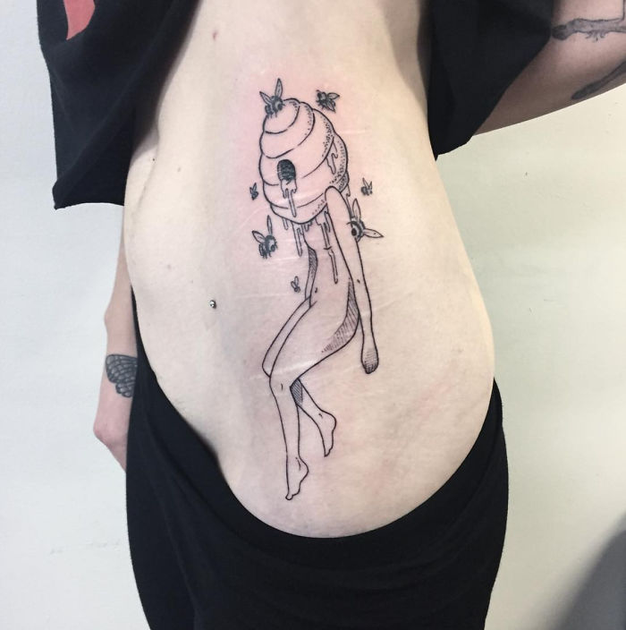 Tattoo of a headless girl by Molly Jean with a beehive head on a person's side.