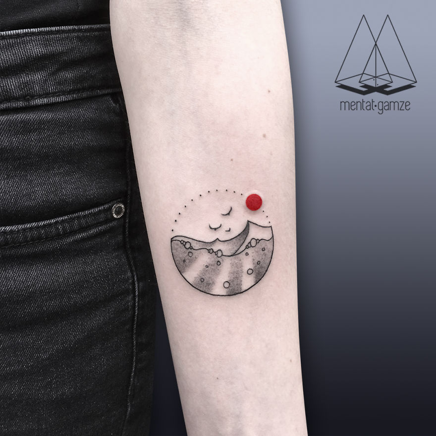 Tattoo with a red dot on an arm, featuring a serene landscape design by tattoo artist.