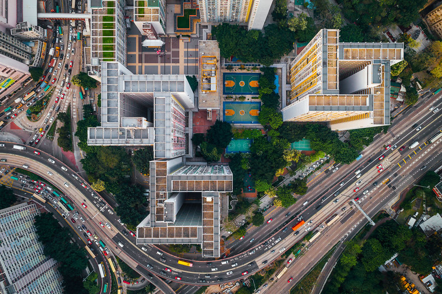 Aerial view of dense Hong Kong housing and busy roads showing claustrophobic living conditions from above.