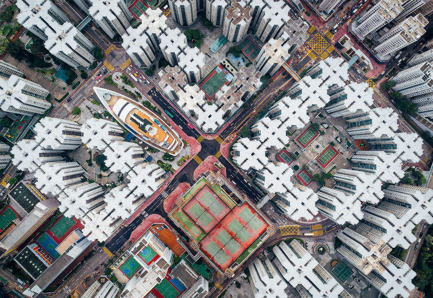 Aerial view of high-density residential buildings and tennis courts showing claustrophobic living in Hong Kong.