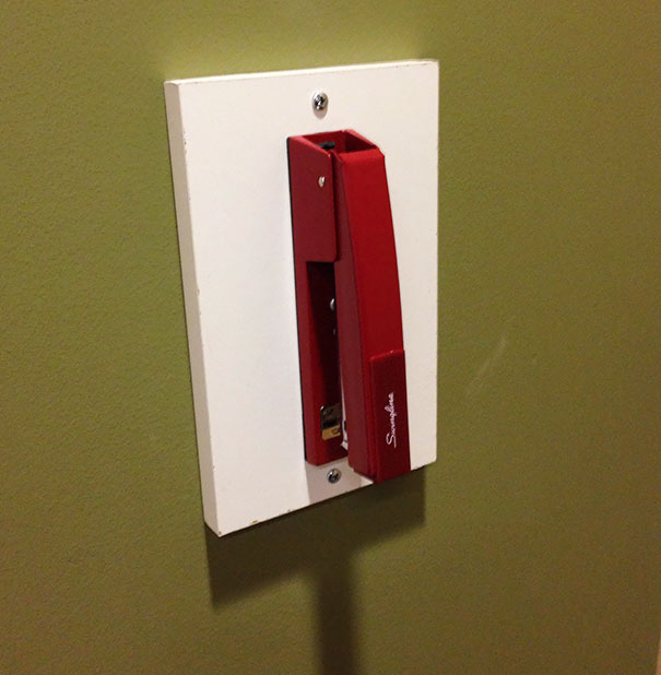 Red stapler cleverly mounted on a wall as a quirky school idea.