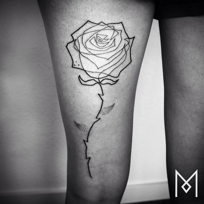 Single line rose tattoo by Mo Ganji on a person's thigh.