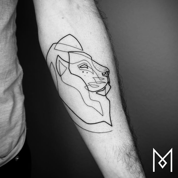 Minimalist lion tattoo using a single continuous line by artist Mo Ganji on forearm.