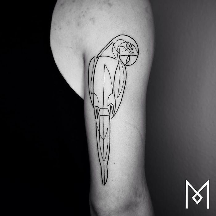 Single continuous line tattoo of a parrot on an arm, designed by Mo Ganji.