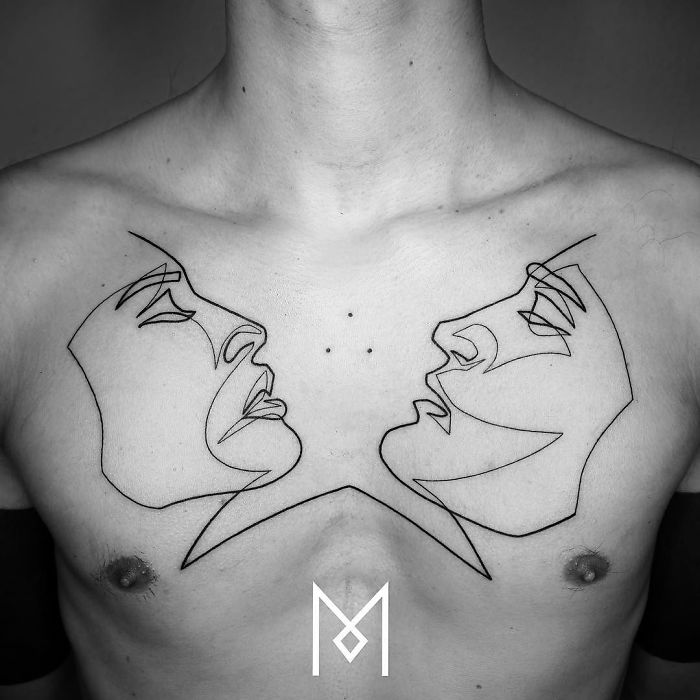 Chest tattoo of two faces created using a single continuous line by Mo Ganji.