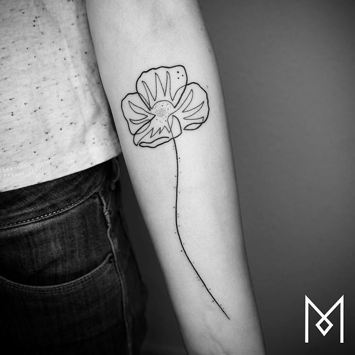 Single continuous line tattoo of a flower on an arm by Mo Ganji.