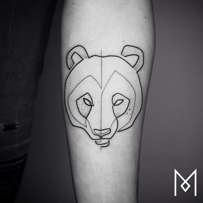 Single continuous line tattoo of an animal face by Mo Ganji on forearm.