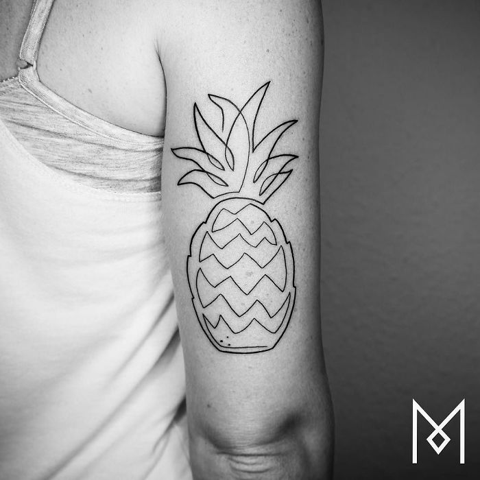 Single continuous line tattoo of a pineapple on upper arm by Mo Ganji.