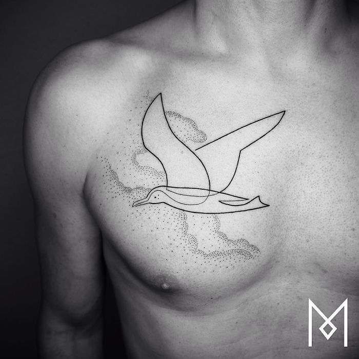 Single continuous line tattoo of a bird on a person's chest by Mo Ganji.