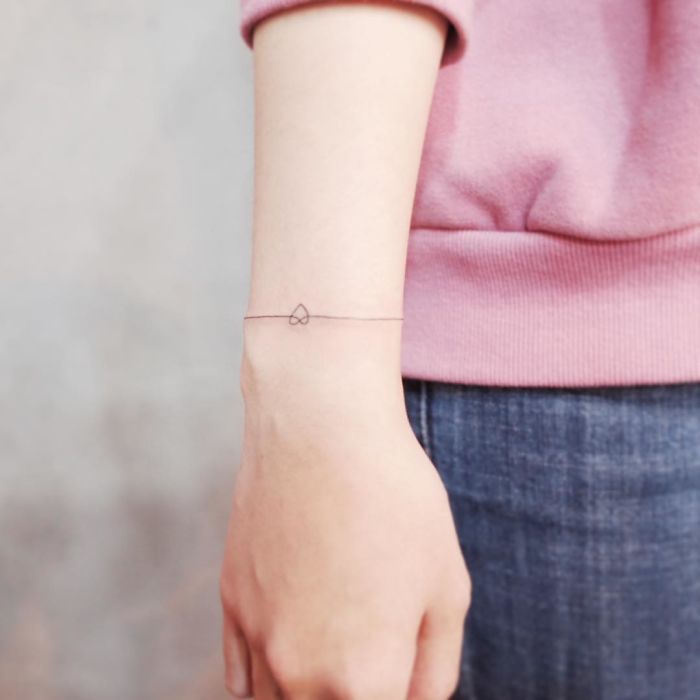 Minimalist tattoo of a small infinity symbol on the wrist, showcasing discreet and tiny tattoo design.
