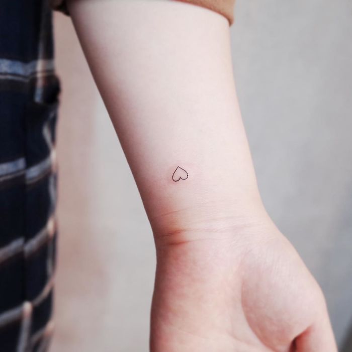 Minimalist heart tattoo on wrist, perfect for those who love discreet body art.