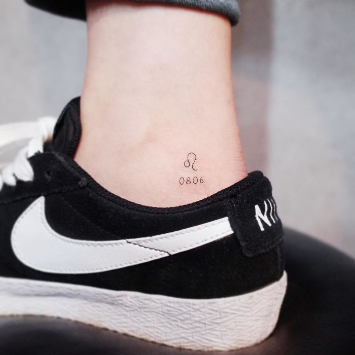 Minimalist tiny tattoo of Leo symbol and numbers on ankle above black sneaker.