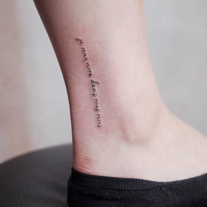 Minimalist tattoo on ankle with elegant script, perfect for those who appreciate tiny discreet tattoos.