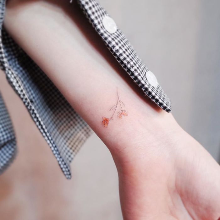 Minimalism tattoo: delicate floral design on a wrist.