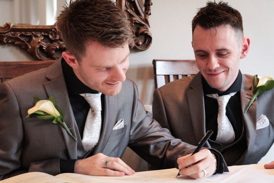 One man signing something and other is looking 