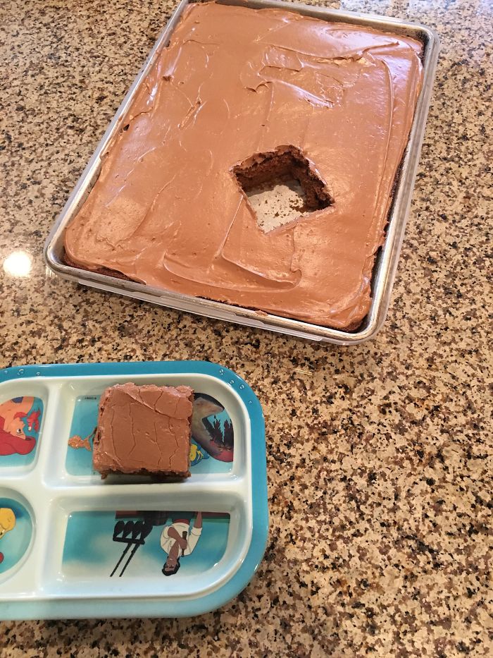 Chocolate cake with a square piece missing, illustrating a humorous moment in married life.
