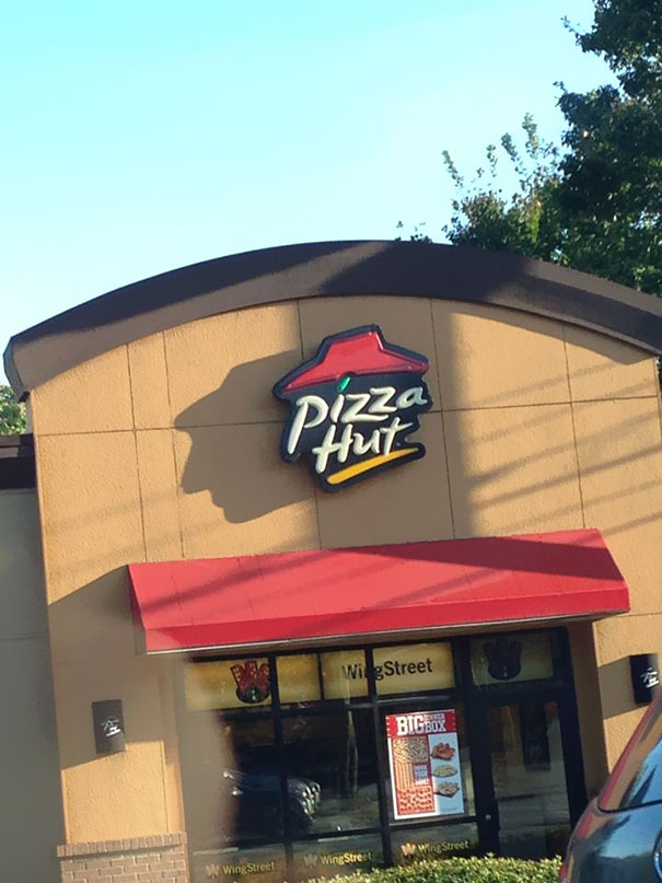 Pizza Hut Sign Shadow Looks Like A Man With A Hat
