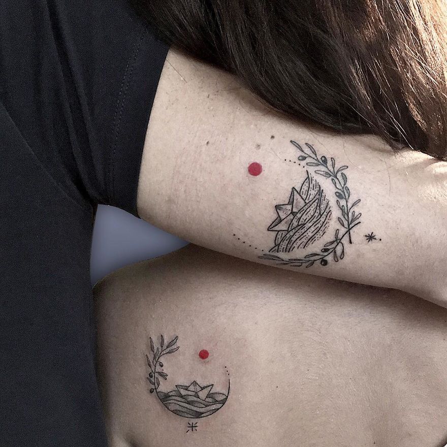 Two abstract tattoos with a red dot, showcasing intricate designs on two people’s arms.