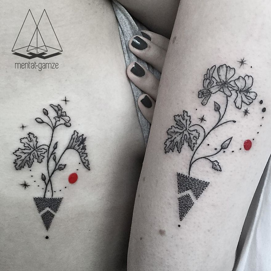 Floral tattoo designs with red dots on two arms, showcasing intricate line work and geometric elements.