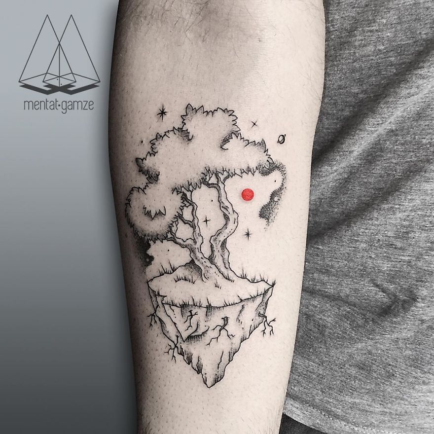 Tattoo of floating island with tree and a red dot, symbolizing artistic transformation on forearm.
