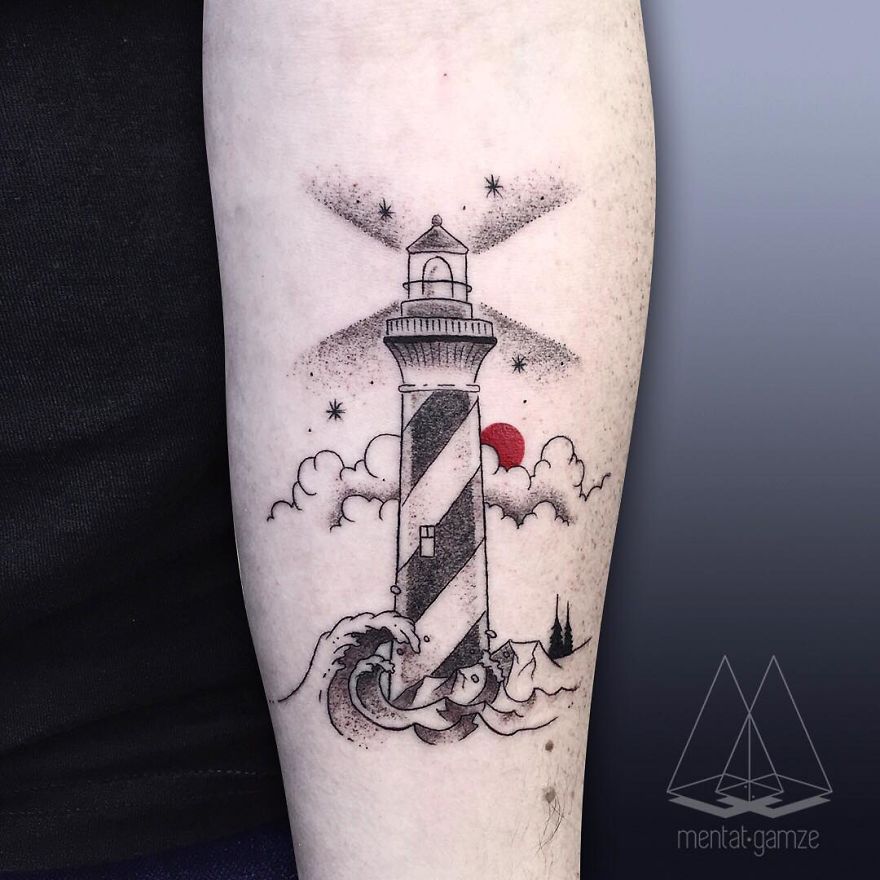 Tattoo artist's lighthouse design with a red dot on an arm, featuring stars and waves in a black and white style.