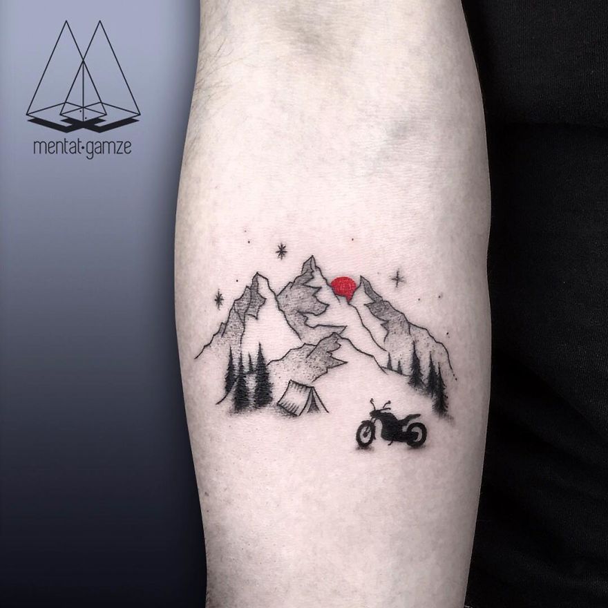 Tattoo depicting mountains, trees, a tent, and a motorcycle under a red sun.