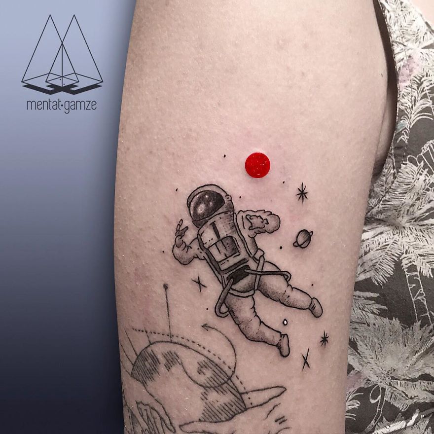 Tattoo of an astronaut floating in space with a red dot, symbolizing a creative career change to tattoo artist.