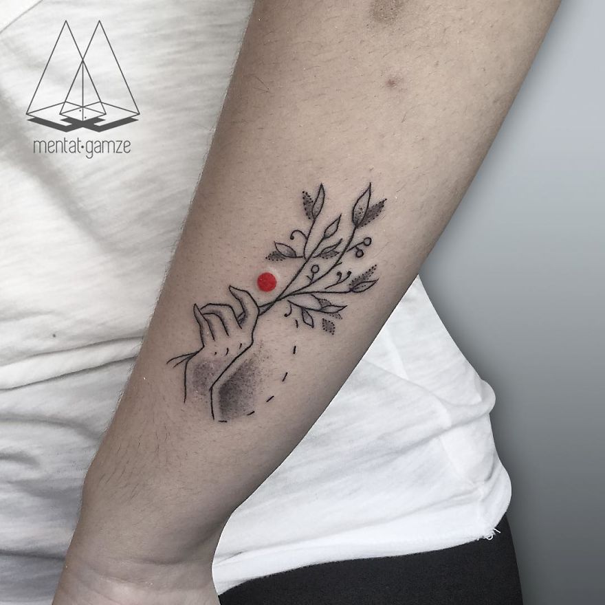 Tattoo of a hand holding a branch with a red dot on an arm, showcasing artistic tattoo skills.